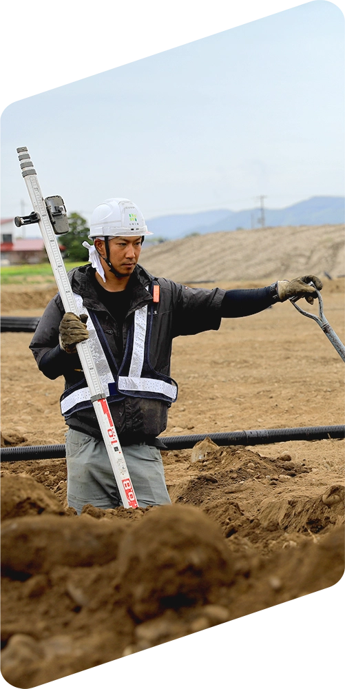 土木工事現場で測量を行う作業員