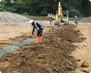 農業土木で排水管を敷設する作業員